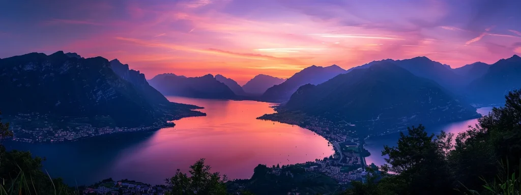 a breathtaking sunset casts vibrant hues of orange and purple over a tranquil lake, with silhouetted mountains framing the horizon.