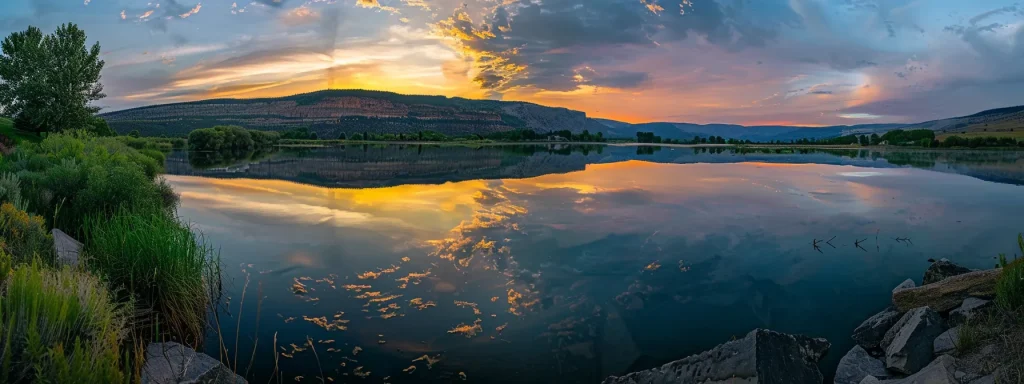 a vibrant sunset casts golden hues over a tranquil lake, with majestic mountains reflected in the still water, creating a serene and breathtaking landscape.